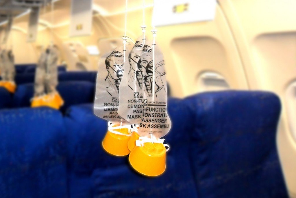Two oxygen masks dangle freely from the roof of an airplane. (Credit: ScienceABC)